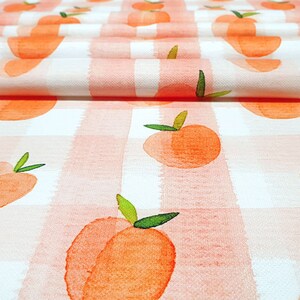 May include: Peach print fabric with a white and pink gingham pattern. The fabric is folded in half and the peaches are watercolour style.