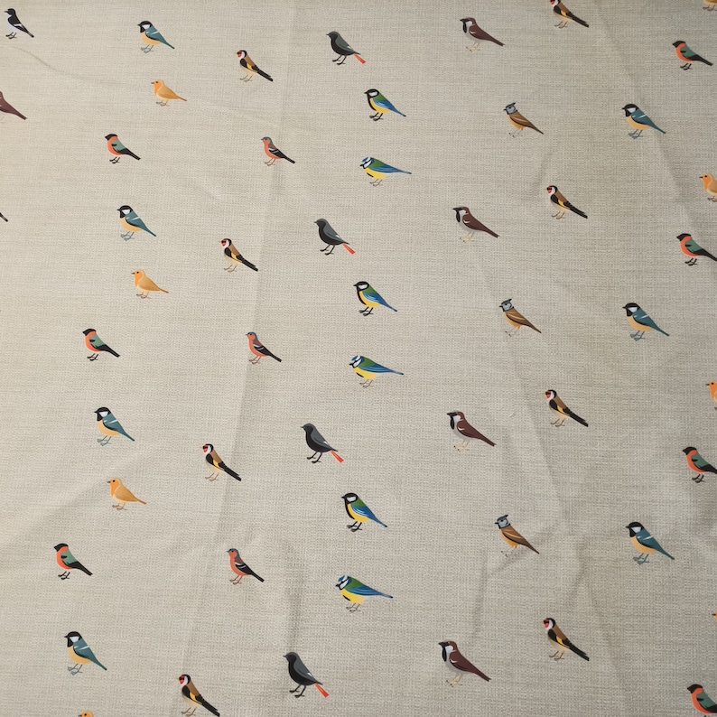 May include: A beige fabric with a repeating pattern of various colorful birds. The birds are all different species and are arranged in a random pattern.