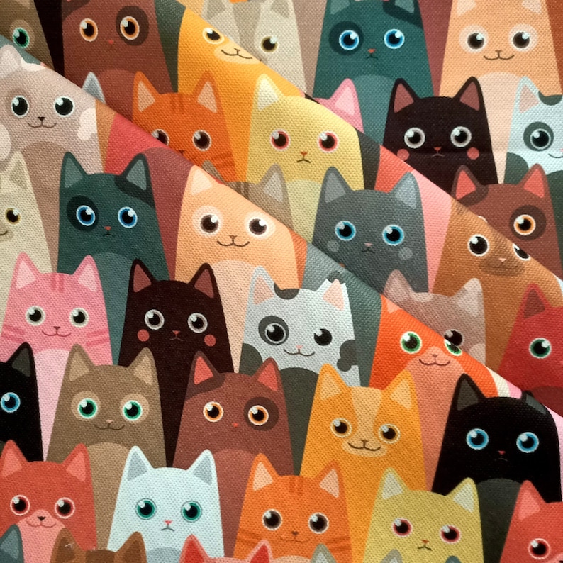 May include: A colorful fabric with a repeating pattern of cartoon cats in various colors and poses. The cats are all smiling and have different colored eyes and fur.