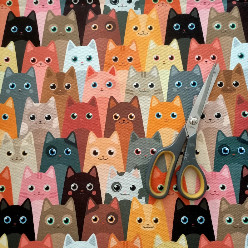 May include: A colorful fabric with a repeating pattern of cartoon cats. The cats are in various poses and colors, including black, white, brown, orange, red, pink, and blue.