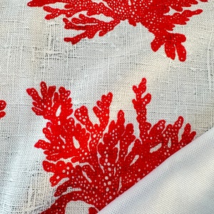 May include: Red coral print on a white linen fabric. The fabric is folded over, showing the white underside.