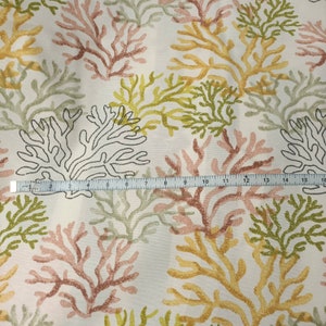 Puede incluir: Tela blanca con un patr&oacute;n repetido de ramas de coral en tonos de rosa, amarillo y verde. La tela se mide con una regla, mostrando una longitud de 40,6 cm.