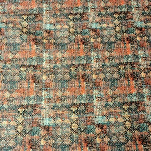 May include: A close-up of a fabric with a geometric pattern in shades of orange, teal, and brown. The fabric has a textured, woven look.