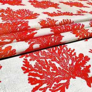 May include: Red coral reef print fabric with a white background. The fabric is folded and shows the pattern repeating.