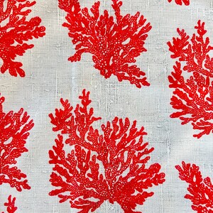 May include: Red coral reef pattern on a white linen fabric. The coral is a stylized design with a repeating pattern.