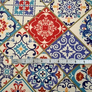 May include: A colorful fabric with a repeating pattern of blue, red, and white tiles. The tiles have intricate designs and are arranged in a diamond pattern.
