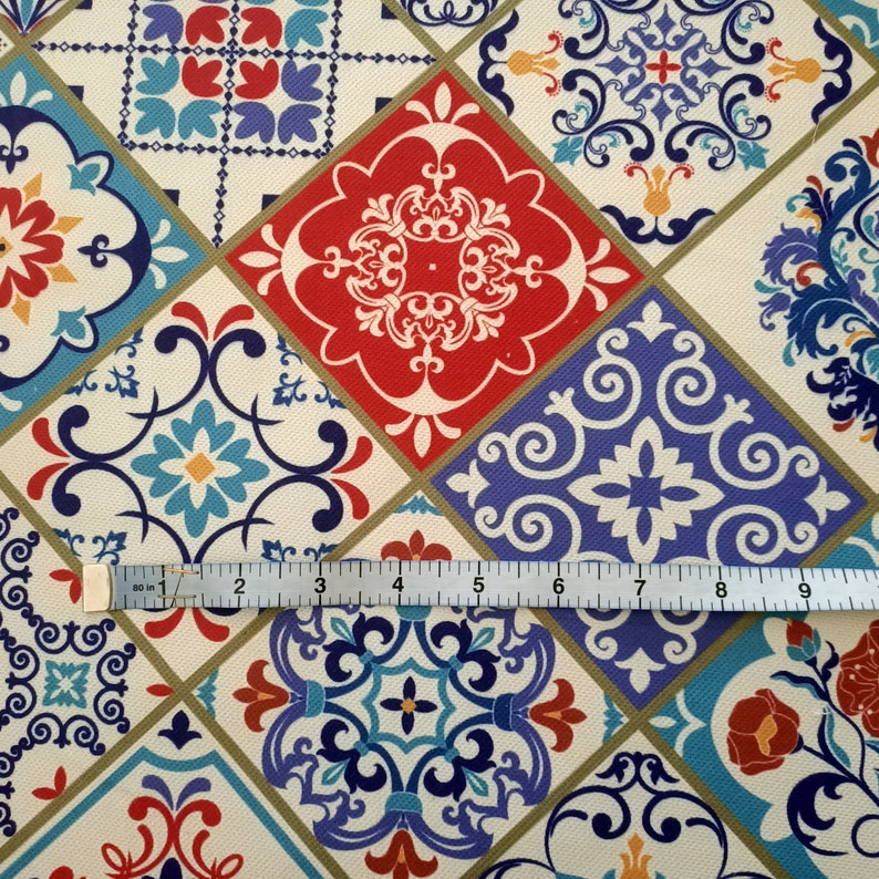 May include: A colorful fabric with a repeating pattern of blue, red, and white tiles. The tiles have intricate designs and are arranged in a diamond pattern.