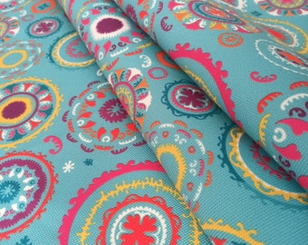 May include: Teal fabric with a repeating pattern of colorful, stylized floral medallions. The fabric is folded over, showing the pattern on both sides.