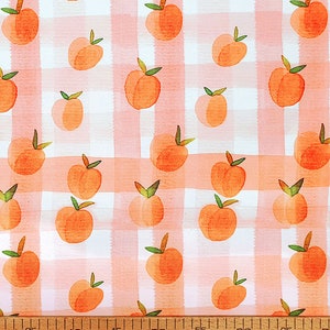 May include: Peach print fabric with a pink and white gingham pattern. The fabric features a repeating pattern of peaches with green leaves.