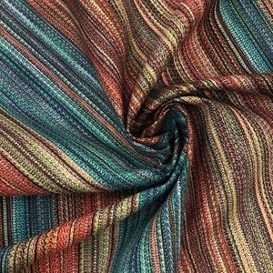 May include: Close-up of a fabric with a striped pattern in shades of teal, red, brown, and beige. The fabric is tightly woven, with a slight sheen, and is arranged in soft folds. The overall effect is a rich, textured textile.