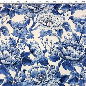 Op de afbeelding: Blauw-witte bloemenstof met een herhalend patroon van pioenen en vogels. De stof heeft een witte achtergrond met blauwe bloemen en vogels.