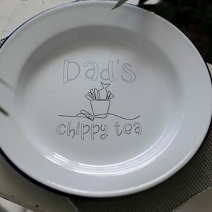 May include: White enamel dinner plate with a black outline of a bucket of chips and the text "Dad's Chippy Tea".