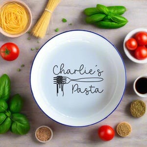 May include: White ceramic bowl with a blue rim, featuring the text "Charlie's Pasta" and a black line drawing of a fork with pasta on it.