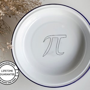 May include: White enamel pie dish with a blue rim and the symbol for pi printed on the bottom. The dish is dishwasher safe and has a lifetime guarantee. The text "One Mama One Shed" is printed on the bottom of the dish.