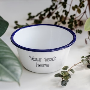 May include: White enamel bowl with a blue rim. The bowl has the text "Your text here" printed on the front.