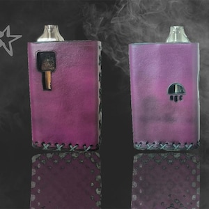 May include: Two purple leather vape mod cases with silver tops. The case on the left has a small rectangular cutout, while the case on the right has a round cutout.