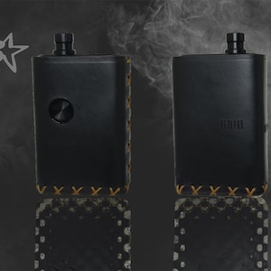 Può includere: Due mod vape in pelle nera con bordino e cuciture in pelle marrone. I mod hanno una parte superiore in metallo nero e un pulsante nero sul davanti.
