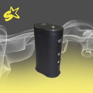 May include: A black leather case for an electronic cigarette. The case has a stitched edge and three silver metal buttons.
