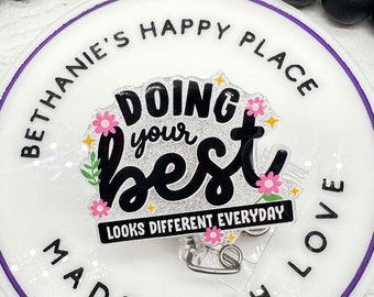 May include: White round badge with a purple border. The badge says "Bethanie's Happy Place Made With Love" around the edge. In the center, it says "Doing your best" in black with pink flowers and glitter. Below the text, it says "Looks Different Everyday".