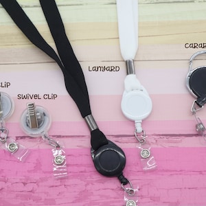 May include: An assortment of lanyards and badge holders. The image shows a black lanyard, a white lanyard, and a carabiner-style badge holder. Also shown are a belt clip and a swivel clip badge holder. The word "Lanyard" is printed on the image.