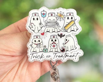 May include: A Halloween-themed badge reel featuring cartoon ghosts dressed as nurses and medical staff. The badge reel has a glittery border and the words "Trick or Treatment" are written on the bottom. The ghosts are holding medical tools.