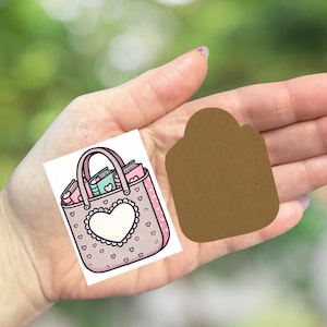 May include: A cartoon illustration of a pink tote bag with a white heart-shaped design and small hearts. The bag contains books and other items. A brown tag is next to the bag.