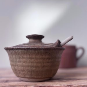 Puede incluir: Un juego de tres tazas de cerámica con un acabado mate moteado. Cada taza presenta un color diferente: azul claro, crema y gris. Las tazas tienen un diseño simple y moderno y un asa cómoda.