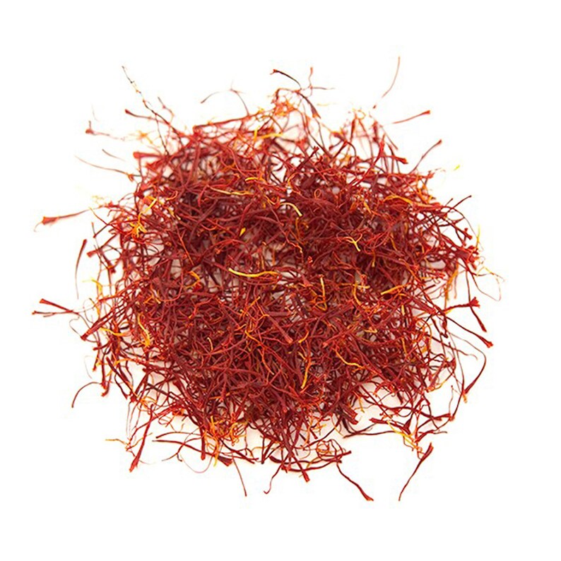 Op de afbeelding: Een hoop gedroogde saffraandraden, een levendige rood-oranje kleur, tegen een witte achtergrond.