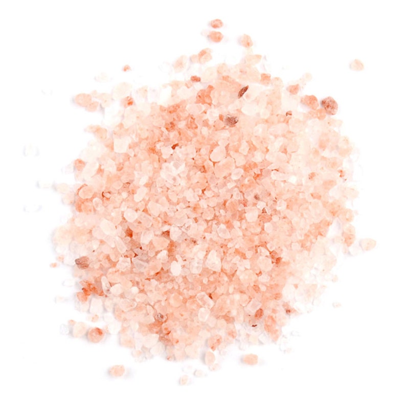 Op de afbeelding: Een close-up van een hoop roze Himalaya-zoutkristallen. Het zout is lichtroze van kleur en heeft een ruwe, kristalachtige textuur.