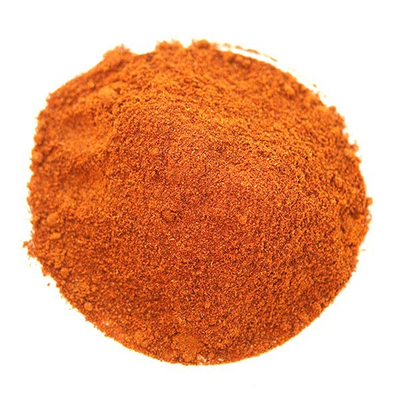 Puede incluir: Un mont&oacute;n de especias finamente molidas, de color marr&oacute;n rojizo, probablemente piment&oacute;n o chile en polvo, sobre un fondo blanco. La textura parece granulada y ligeramente &aacute;spera, lo que sugiere una mezcla de ingredientes secos y molidos. La especia es de un color c&aacute;lido y vibrante.