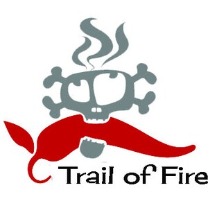 Puede incluir: Un logotipo gr&aacute;fico con una calavera gris con huesos cruzados, vapor y un chile rojo. El texto "Trail of Fire" est&aacute; debajo del gr&aacute;fico. El logotipo est&aacute; sobre un fondo blanco.