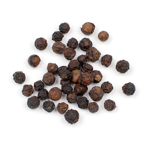 May include: A close-up of a pile of black peppercorns on a white background.