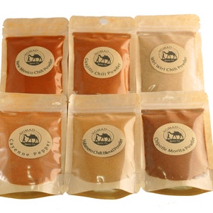 Puede incluir: Seis bolsas de pl&aacute;stico transparente llenas de varios chiles en polvo. Las bolsas est&aacute;n etiquetadas con los nombres de los chiles en polvo, incluyendo New Mexico, Guajillo, Wiri Wiri, Cayenne Pepper, Habanero y Chipotle Morita. Cada bolsa tiene una etiqueta redonda con un logotipo de camello.