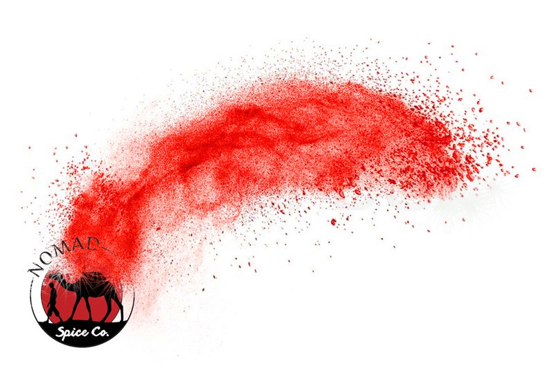 Puede incluir: Imagen din&aacute;mica con una nube de polvo rojo sobre fondo blanco. El logotipo de Nomad Spice Co. est&aacute; en la parte inferior izquierda, con una silueta de camello y el nombre de la empresa.