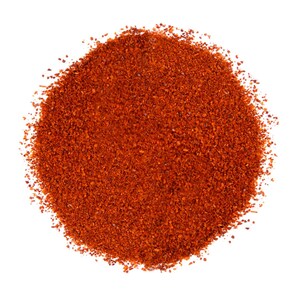 Puede incluir: Primer plano de un mont&oacute;n de pimiento rojo molido, sobre un fondo blanco. El polvo tiene una textura fina y ligeramente granulada. Ideal para contenidos culinarios y proyectos relacionados con la comida.