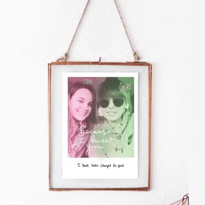May include: A framed photograph with a copper-colored metal frame, suspended by a natural rope. The photo features two young women, with the names "Chloe" and "Claire" above their heads. The text "Because I knew you" and "I have been changed for good" are also visible.