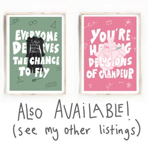 May include: Two framed art prints. One print has a green background with the text "EVERYONE DESERVES THE CHANCE TO FLY" and a black dress illustration. The other print has a pink background with the text "YOU'RE HAVING DELUSIONS OF GRANDEUR" and a dress illustration.