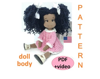 Könnte beinhalten: Häkelpuppe-Anleitung als PDF mit Video-Tutorial. Die Puppe hat braune Haut, lockiges schwarzes Haar und trägt ein rosa Kleid mit weißen Verzierungen. Die Anleitung enthält Anweisungen für den Puppenkörper und das Kleid.