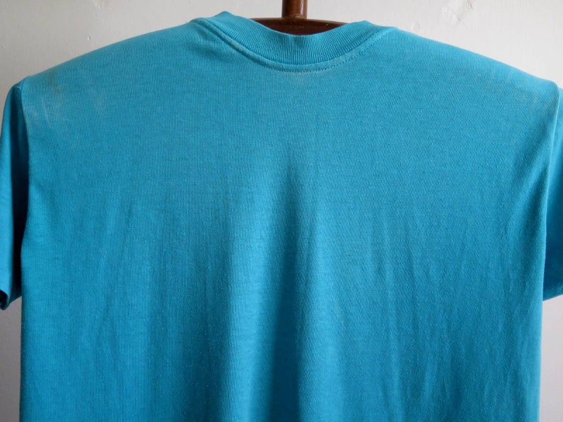 May include: A plain, turquoise blue t-shirt with a crew neck.