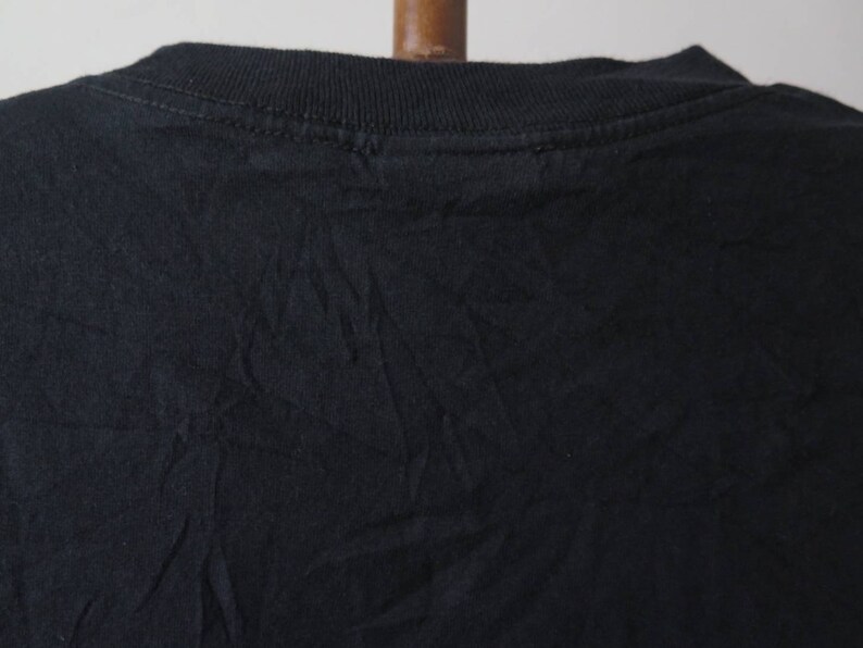 May include: Black t-shirt with a crew neck.