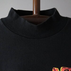 Op de afbeelding: Zwart T-shirt met een geribbelde mock neck.