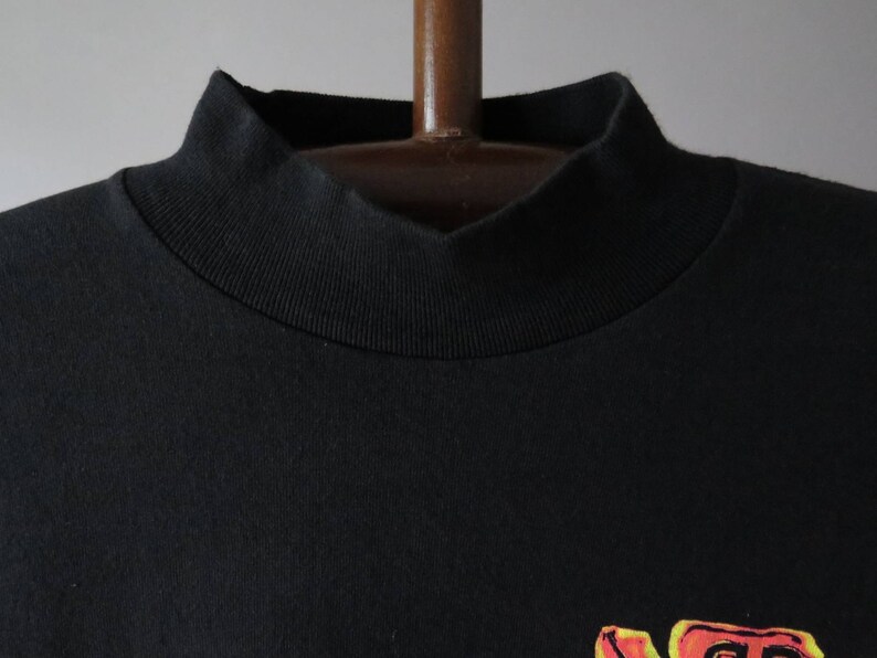Op de afbeelding: Zwart T-shirt met een geribbelde mock neck.