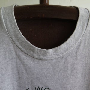 May include: A gray t-shirt with a crew neck. The shirt is on a hanger.
