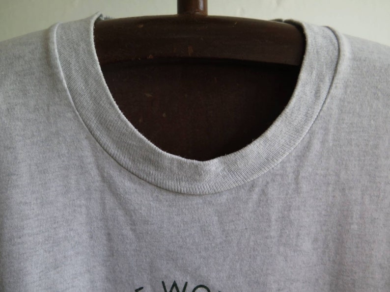 May include: A gray t-shirt with a crew neck. The shirt is on a hanger.