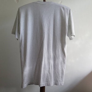 May include: A plain grey t-shirt with short sleeves.