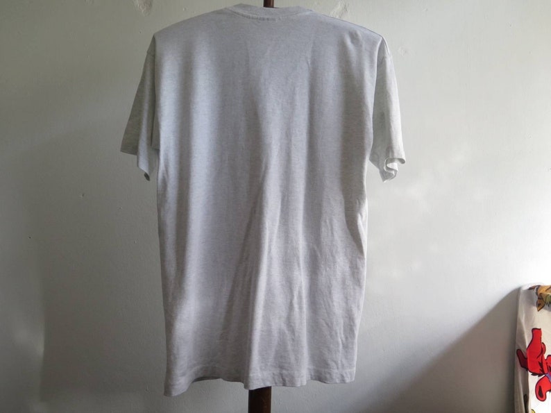 May include: A plain grey t-shirt with short sleeves.