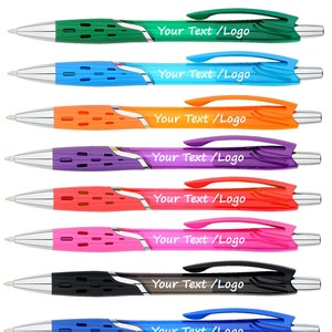 May include: Eight ballpoint pens in different colors, including green, blue, orange, purple, red, pink, black, and blue. Each pen has a clear plastic body with a silver clip and a chrome tip. The pens are all the same size and shape. The text "Your Text/Logo" is printed on each pen.