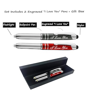 May include: Two silver pens with black and red accents in a black gift box. The pens have a stylus tip and a flashlight on one end. The pens are engraved with the words "I Love You".