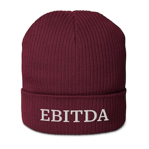 May include: A burgundy beanie with the word "EBITDA" embroidered in white. The hat is made of a ribbed knit fabric and has a folded cuff. This warm hat is suitable for cold weather.