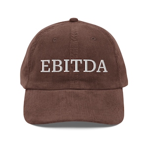May include: A brown corduroy baseball cap with the word "EBITDA" embroidered in white on the front.